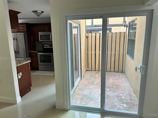an empty room with wooden floor closet and windows