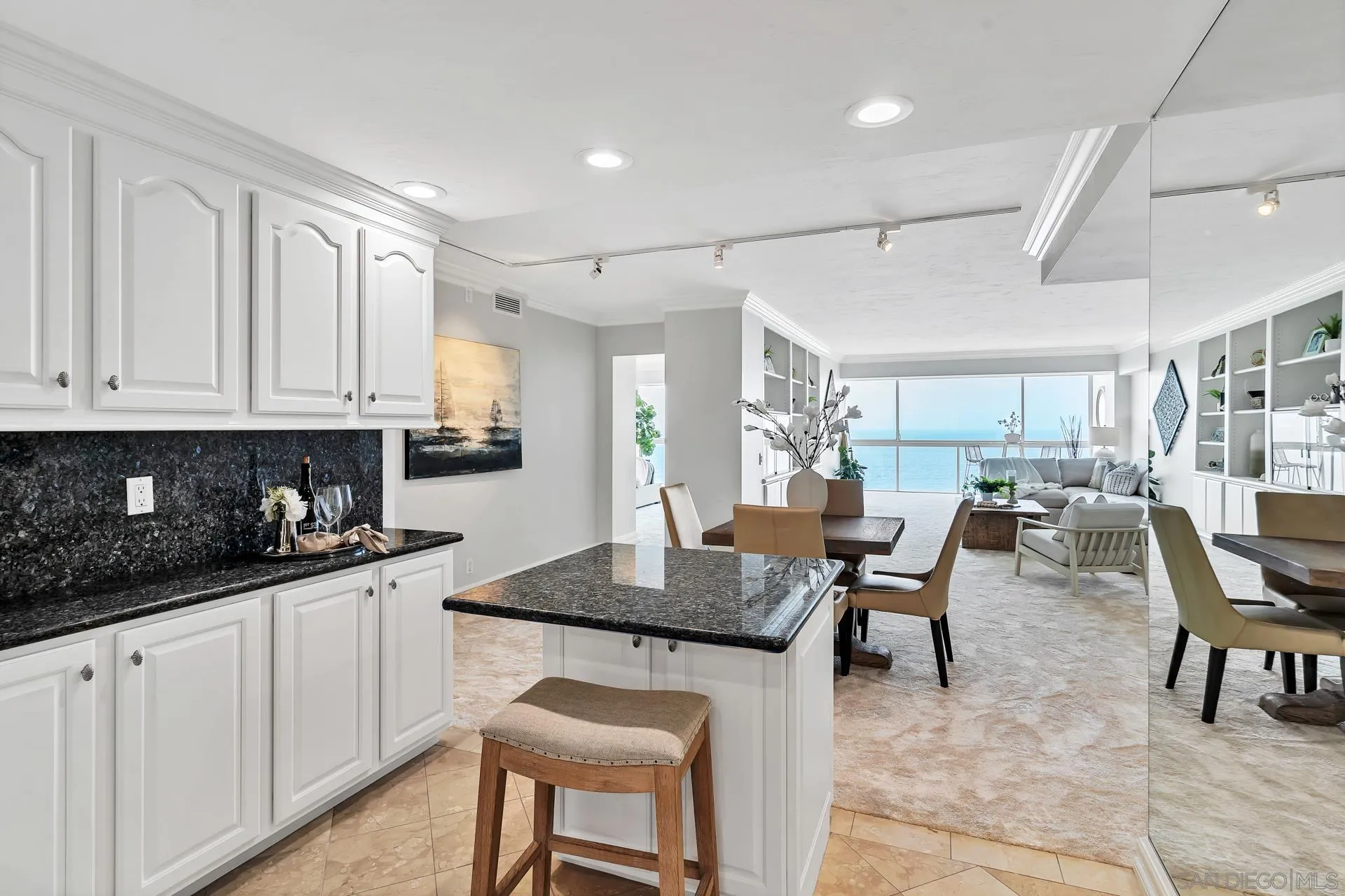 939 Coast Boulevard, Unit 12C La Jolla, CA 92037 - Photo 16 of 41 a kitchen with granite countertop a table chairs sink and cabinets