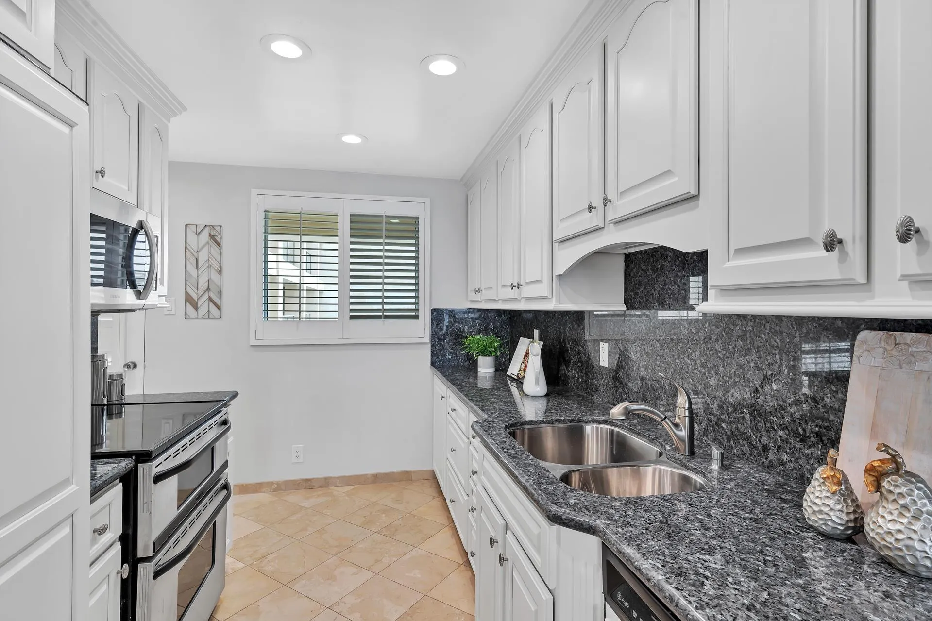 939 Coast Boulevard, Unit 12C La Jolla, CA 92037 - Photo 18 of 41 a kitchen with granite countertop a sink a stove and cabinets