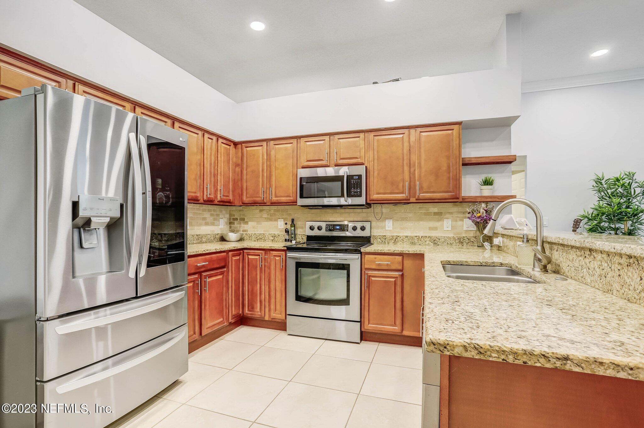613 Hummingbird Court St. Johns, FL 32259 - Photo 8 of 29 a kitchen with stainless steel appliances granite countertop a refrigerator sink and stove