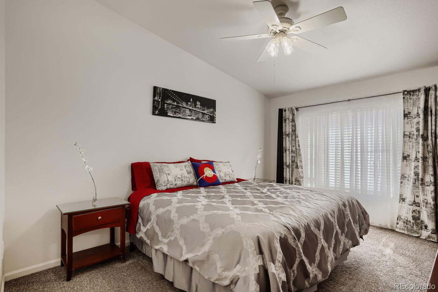8437 South Thunder Ridge Way, Unit 204 Highlands Ranch, CO 80126 - Photo 11 of 27 a bedroom with a bed and a chandelier