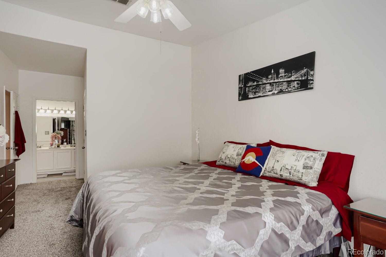 8437 South Thunder Ridge Way, Unit 204 Highlands Ranch, CO 80126 - Photo 12 of 27 a bedroom with a bed and a painting on the wall