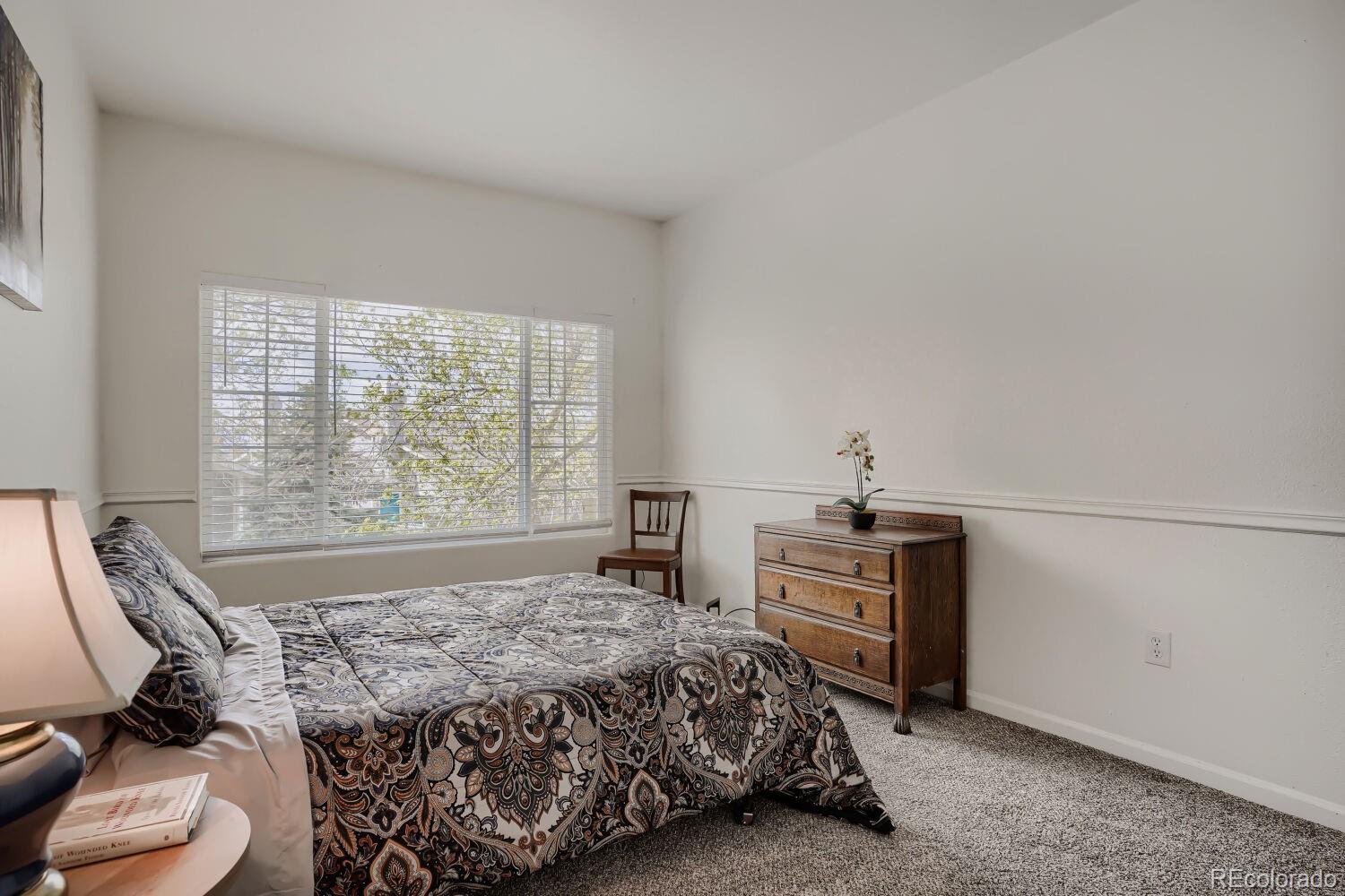 8437 South Thunder Ridge Way, Unit 204 Highlands Ranch, CO 80126 - Photo 16 of 27 a bedroom with a bed and a stove top oven