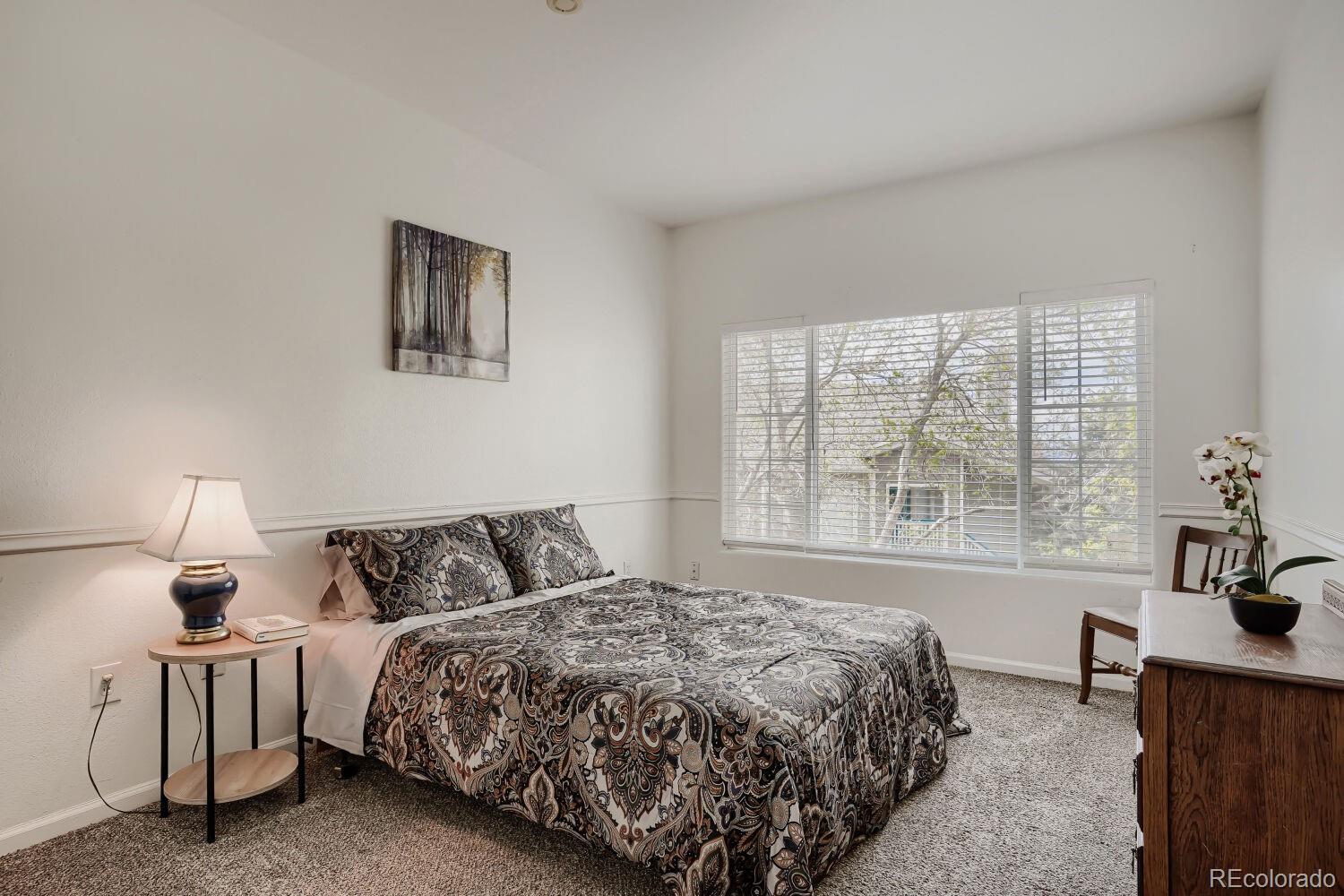 8437 South Thunder Ridge Way, Unit 204 Highlands Ranch, CO 80126 - Photo 17 of 27 a bedroom with a bed and window