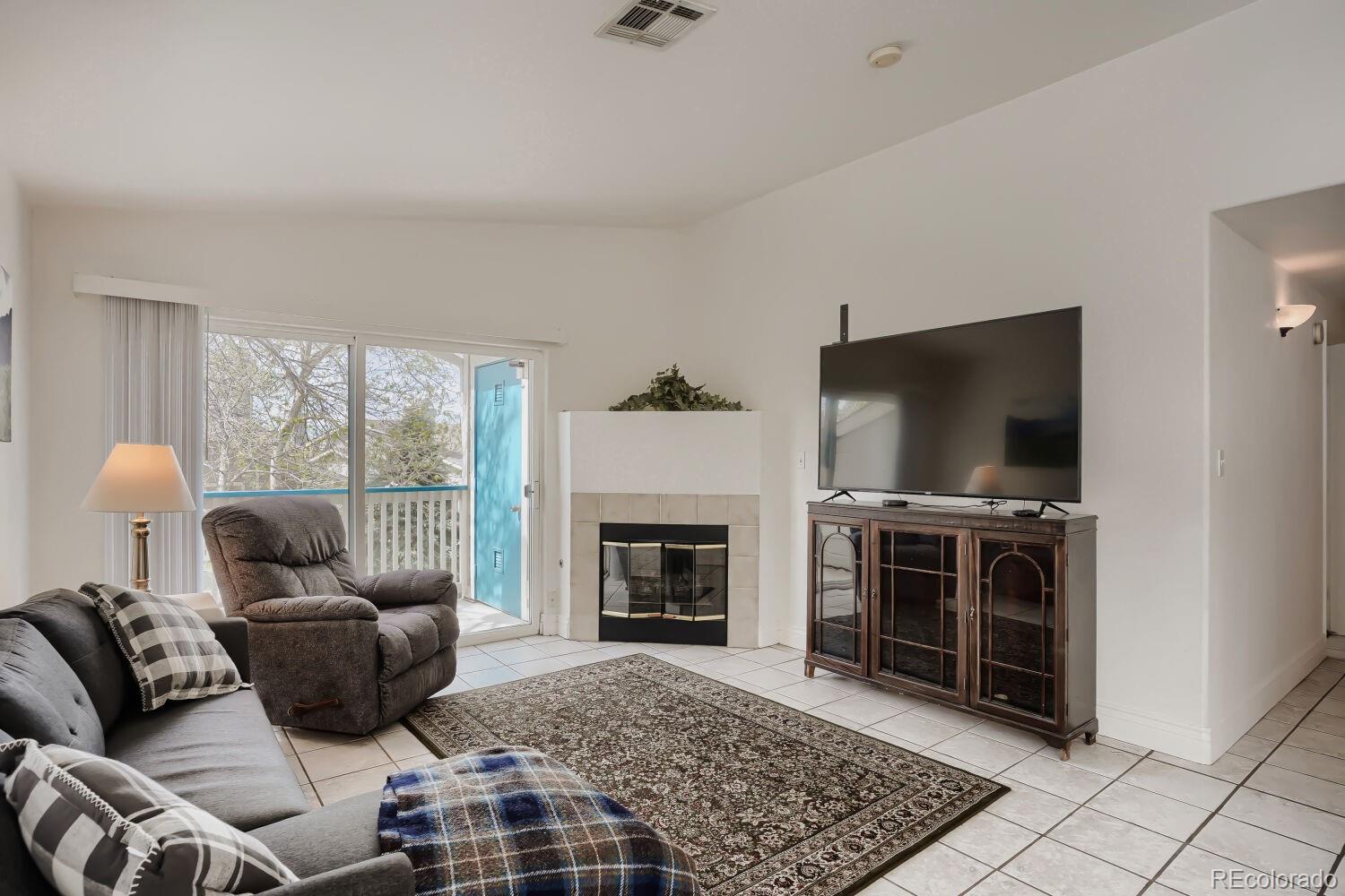 8437 South Thunder Ridge Way, Unit 204 Highlands Ranch, CO 80126 - Photo 2 of 27 a living room with furniture a flat screen tv and a fireplace