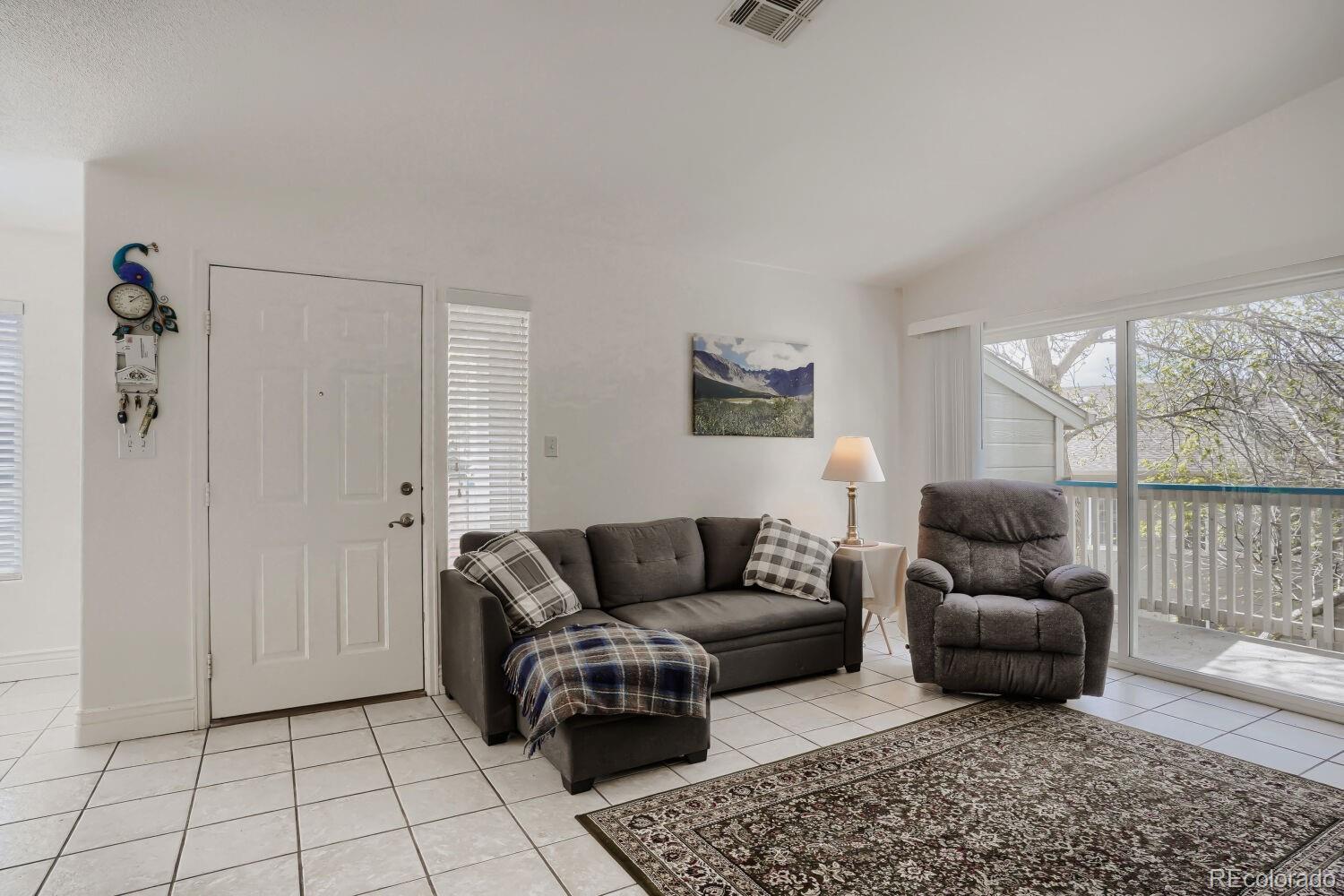 8437 South Thunder Ridge Way, Unit 204 Highlands Ranch, CO 80126 - Photo 3 of 27 a living room with furniture and a rug