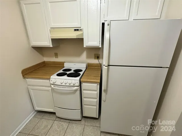 a white refrigerator freezer and a stove sitting inside of a kitchen