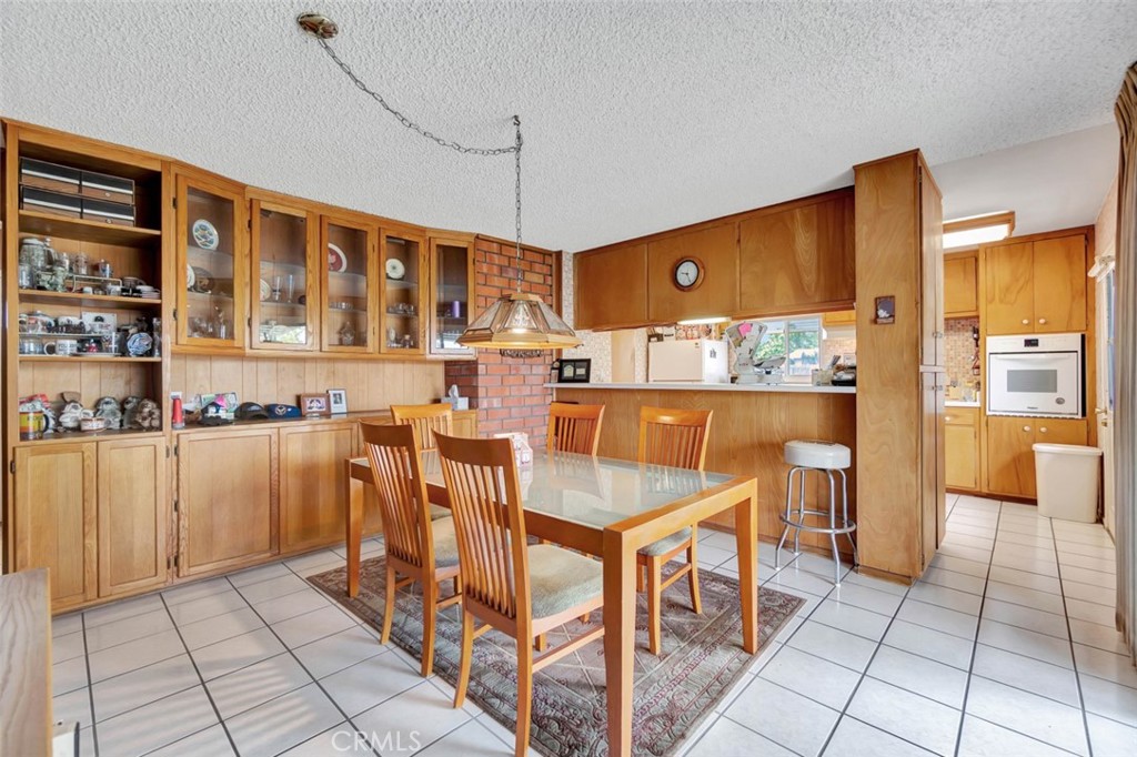 1602 Minorca Drive Costa Mesa, CA 92626 - Photo 13 of 33 a dining hall with stainless steel appliances kitchen island granite countertop a table and chairs