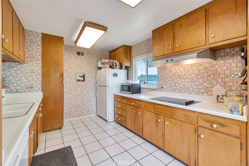 1602 Minorca Drive Costa Mesa, CA 92626 - Photo 17 of 33 a kitchen with sink cabinets and stove