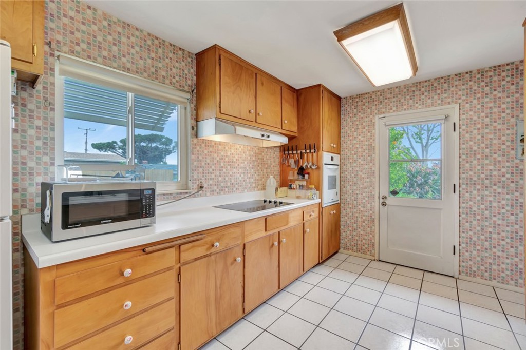 1602 Minorca Drive Costa Mesa, CA 92626 - Photo 21 of 33 a kitchen with stainless steel appliances granite countertop a stove a sink and a microwave