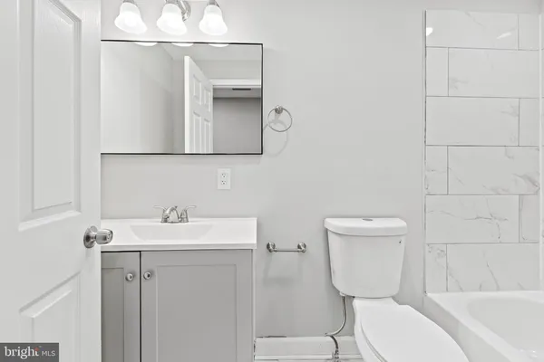 a bathroom with a toilet a sink and mirror