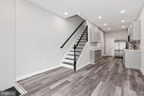 a view of entryway and kitchen with wooden floor