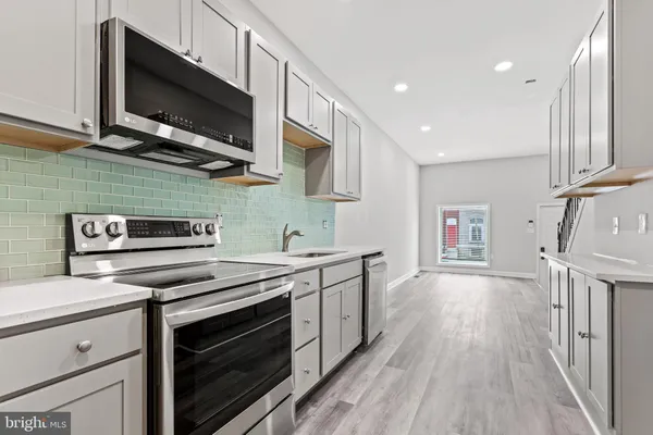 a kitchen with stainless steel appliances a stove sink microwave and cabinets
