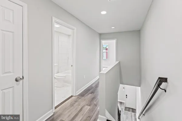 a view of a hallway with white walls and stairs