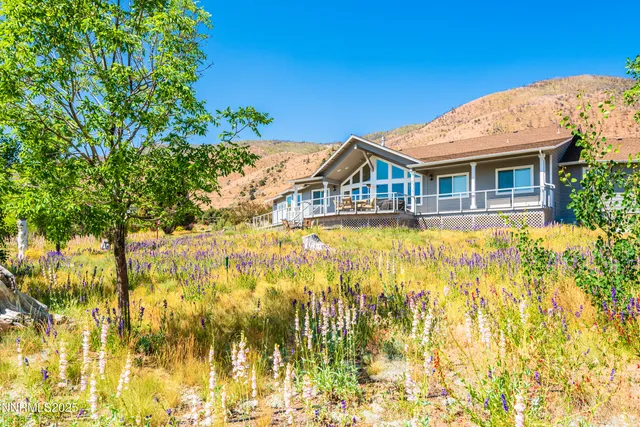 a living room with furniture a flat screen tv and a large window