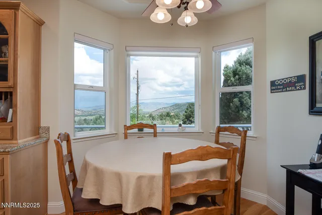 a kitchen with stainless steel appliances granite countertop a dining table chairs stove and refrigerator