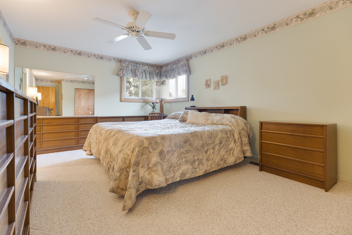 851 Crest Avenue Elk Grove Village, IL 60007 - Photo 12 of 25 a bedroom with a bed and a chandelier