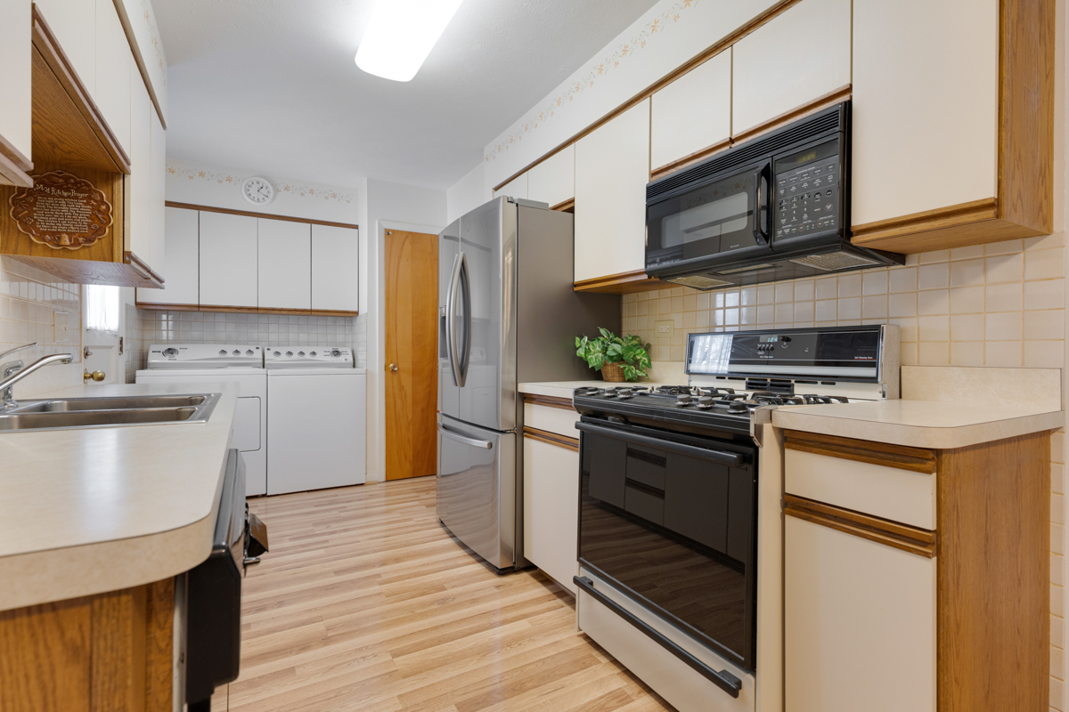 851 Crest Avenue Elk Grove Village, IL 60007 - Photo 7 of 25 a kitchen with stainless steel appliances granite countertop a stove top oven a sink dishwasher and a refrigerator with wooden floor