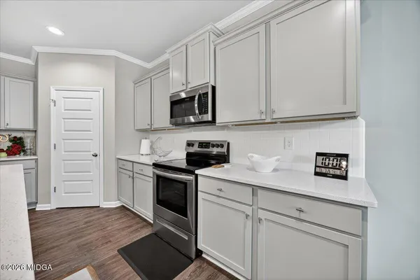 a kitchen with granite countertop white cabinets and stainless steel appliances