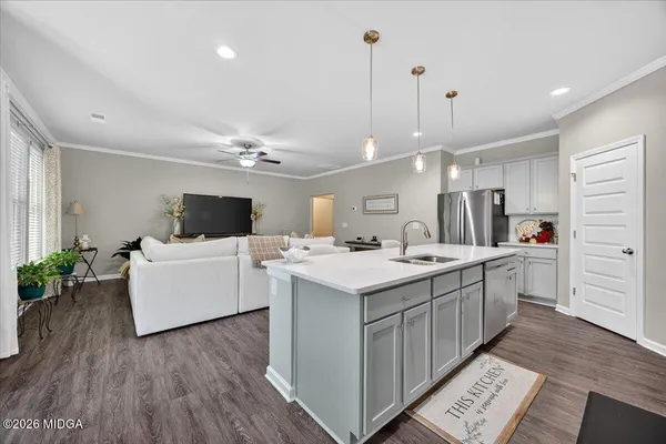 a large white kitchen with a large window a sink and a counter top space