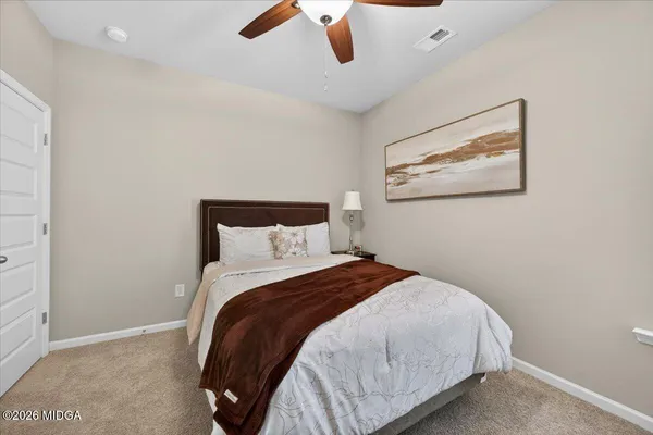 a bedroom with a bed and a painting on the wall