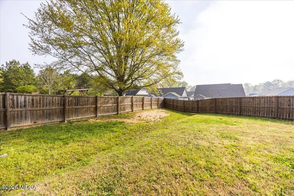 a view of backyard with wooden fence