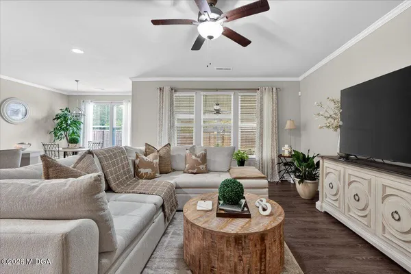 a living room with furniture a flat screen tv and a large window