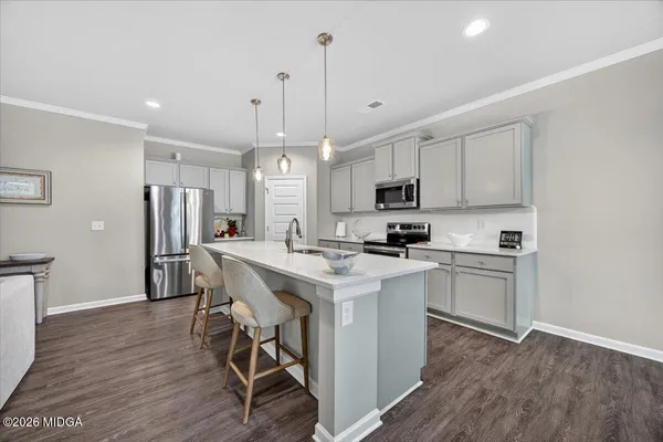 a kitchen with stainless steel appliances granite countertop a sink a stove a refrigerator and microwave