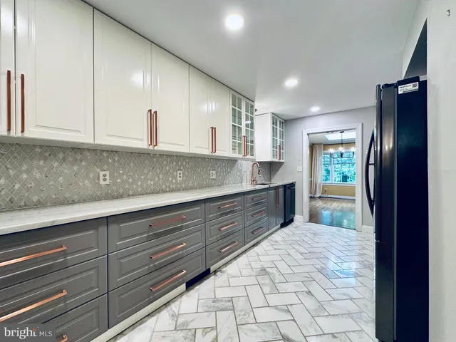 a kitchen with granite countertop a stove a sink and a refrigerator