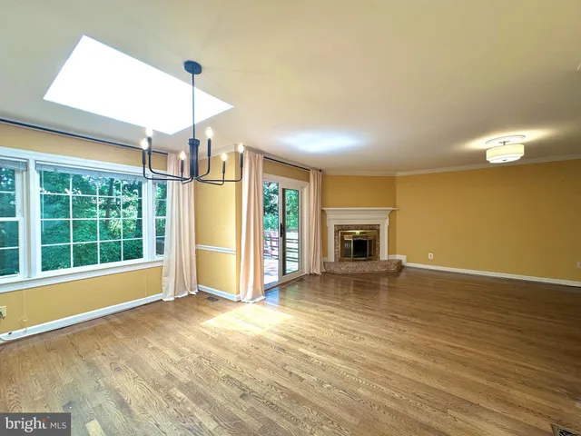 a view of empty room with wooden floor and fireplace