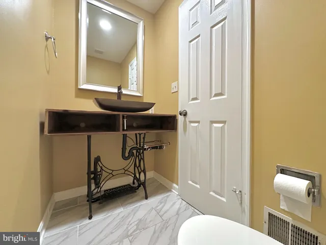 a bathroom with a sink a toilet and mirror