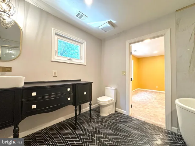 a bathroom with a sink a toilet and a large mirror