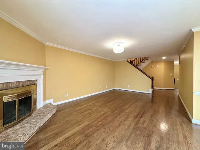 a view of empty room with wooden floor and fireplace