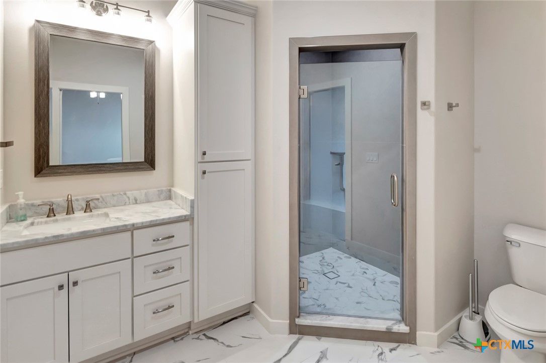 52 Coastal Oaks Loop Port O'Connor, TX 77982 - Photo 14 of 23 a bathroom with a granite countertop toilet sink and shower