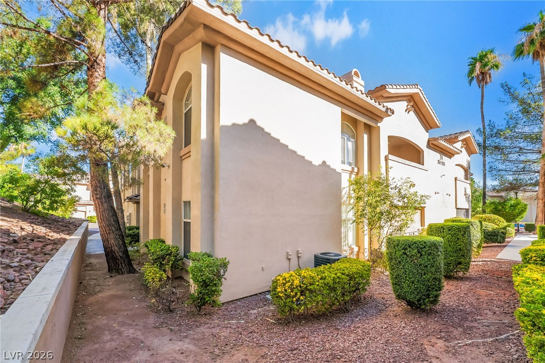 2050 West Warm Springs Road, Unit 2411 Henderson, NV 89014 - Photo 33 of 37 Well-maintained building exterior with Mediterranean-inspired architecture and lush, manicured landscaping.