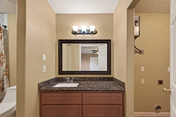 a bathroom with a granite countertop sink and a mirror