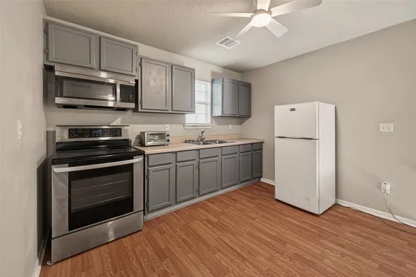 a kitchen with a sink stainless steel appliances and white cabinets