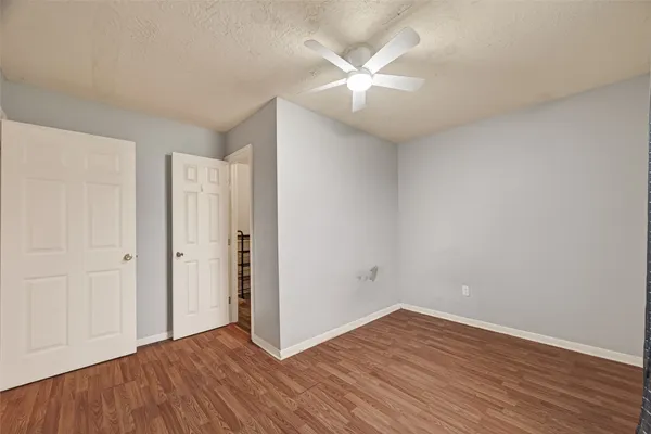 a view of an empty room with wooden floor