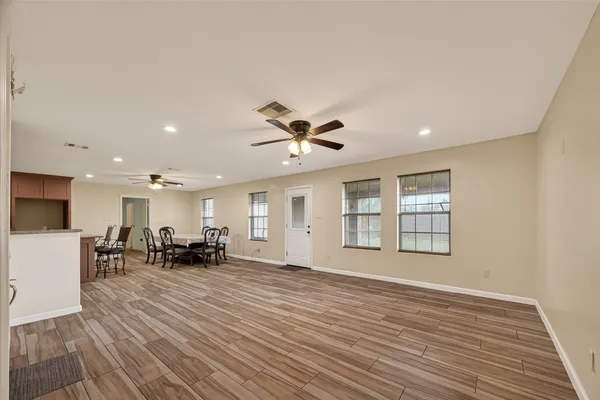 a view of a livingroom with furniture a ceiling fan and wooden floor