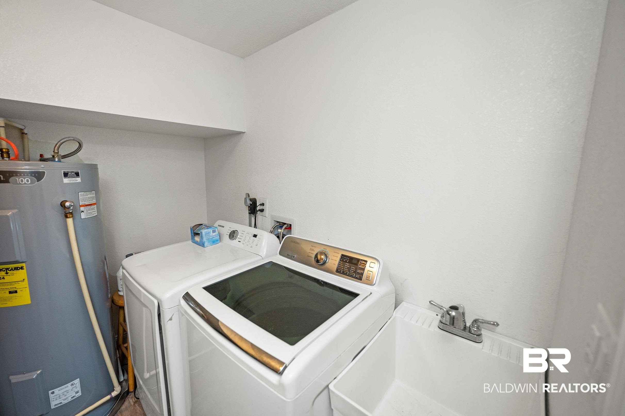 33129 Antietam Road Lillian, AL 36549 - Photo 18 of 31 Dedicated utility area featuring a laundry tub with a chrome faucet, a water heater, and a washer and dryer hookup