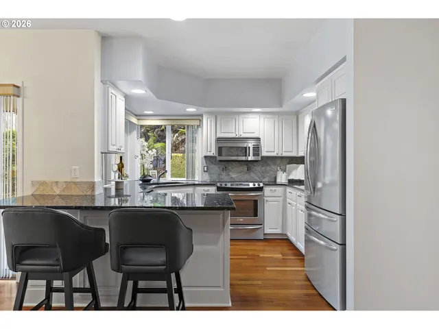 a kitchen with stainless steel appliances kitchen island granite countertop a sink and cabinets