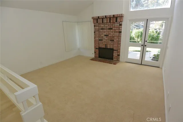 a view of an empty room with a fireplace and a window