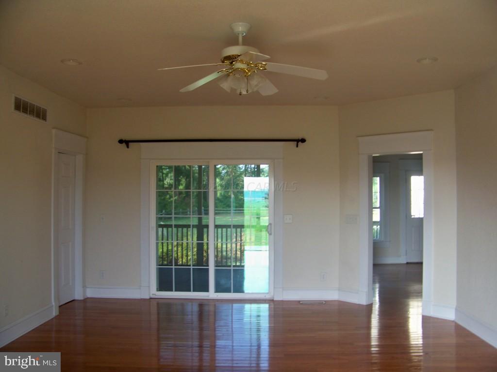 6658 Friendship Road Pittsville, MD 21850 - Photo 5 of 11 a view of a livingroom with wooden floor and a ceiling fan