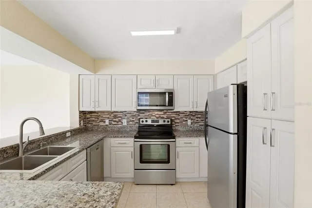 a kitchen with a refrigerator sink and stainless steel appliances