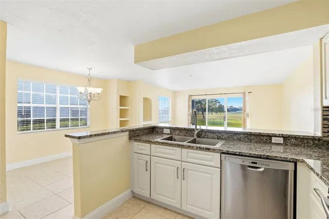 a kitchen with granite countertop a sink and cabinets
