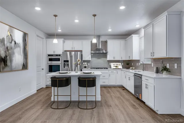 a kitchen with stainless steel appliances kitchen island granite countertop a wooden cabinets and wooden floors