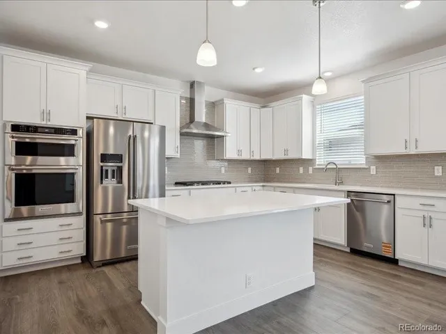 a kitchen with stainless steel appliances a refrigerator sink and microwave