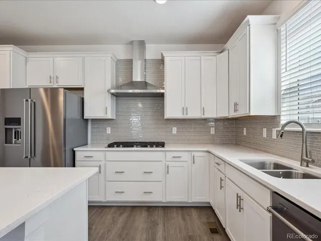 a kitchen with cabinets appliances a sink and a counter top
