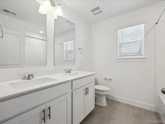 a bathroom with a toilet a sink a mirror a and vanity