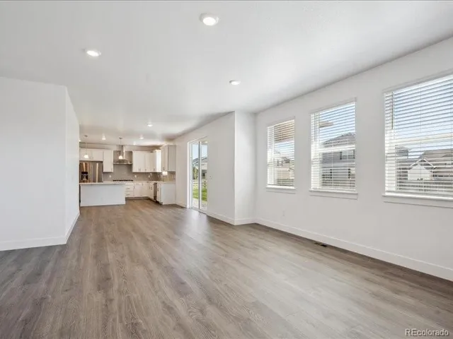 a view of open kitchen with wooden floor and windows